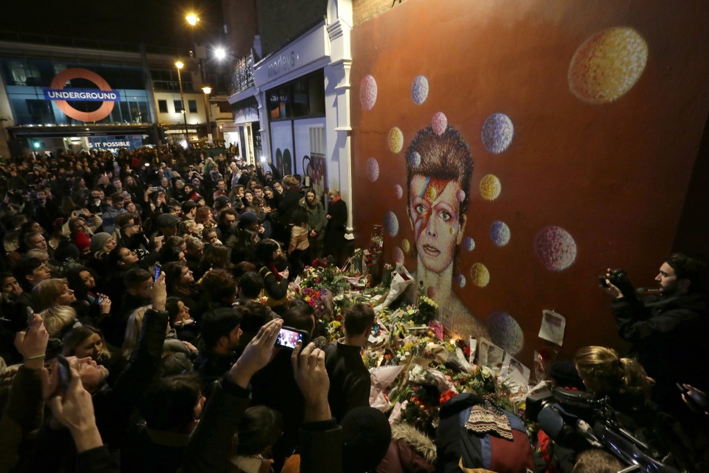 Bowie fans gather near Brixton tube station, near a mural of the late pop star.